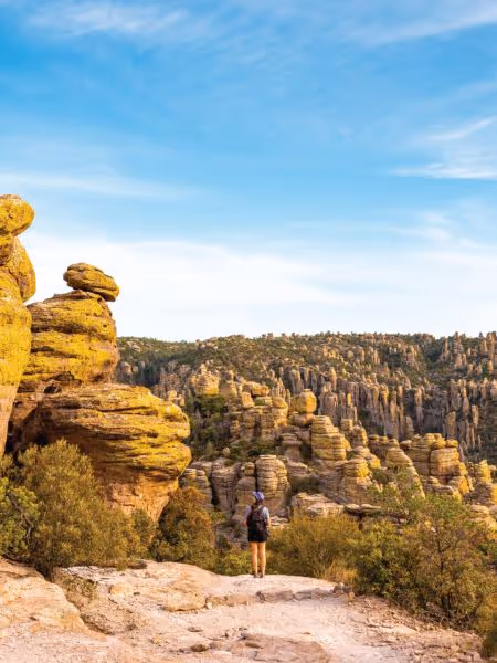Hiker overlooking unique rock formations at Chiricahua National Monument in Arizona
